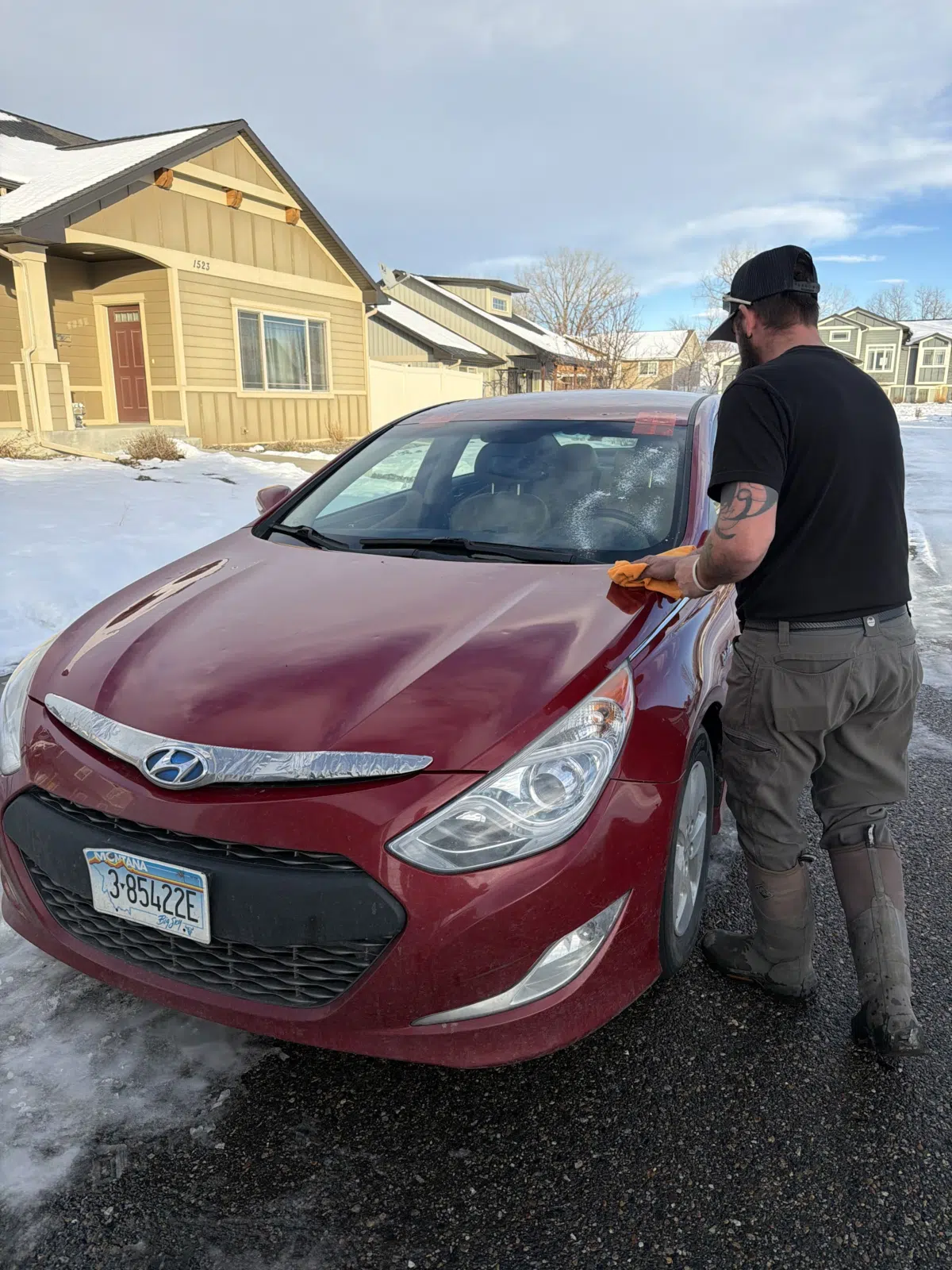 Technician wiping down a red sedan windshield outdoors — A+ Glass LLC in Billings